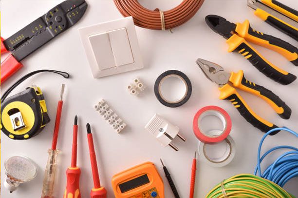 Assorted electrical tools and components laid out on a white surface.