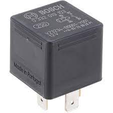 A black relay is sitting on the side of a road.