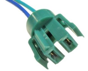 Green electrical connector with blue wires on a white background.