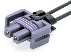 A purple and black connector is connected to two wires.