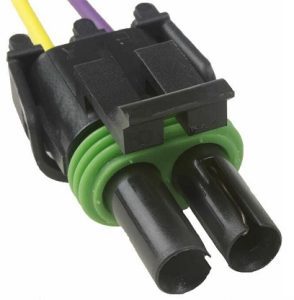 A black and green connector is connected to wires.