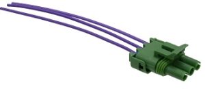 A green connector with purple wires connected to it.