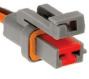A gray and orange connector is connected to an electrical wire.