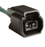 A black connector with green wire attached to it.