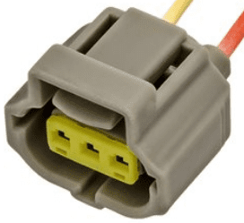 A gray connector with yellow wires attached to it.